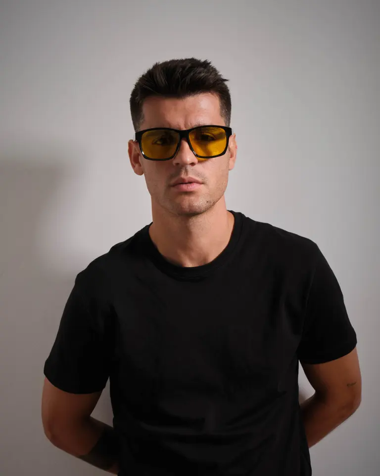Álvaro Morata wearing black-framed Flowglasses Day Sync 02 - Álvaro Edition with yellow lenses in a front-facing portrait.