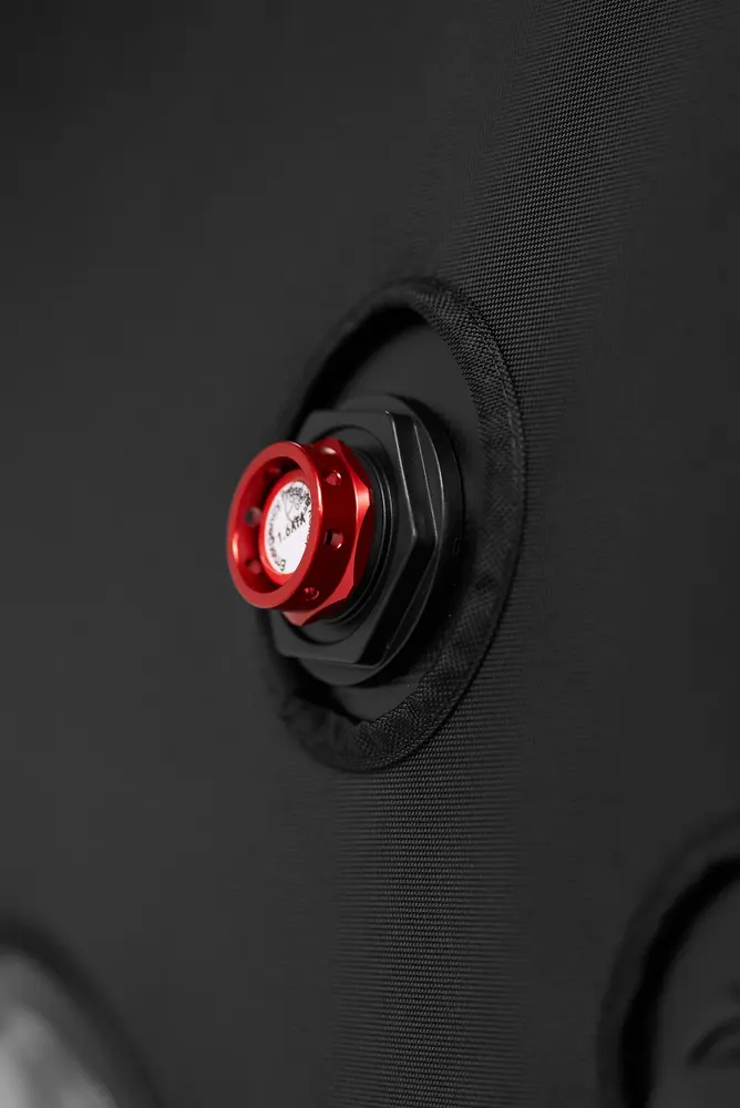 Red emergency pressure relief valve on the textured black shell of the Flowchamber Oxygen Elite 226 Soft-Shell.