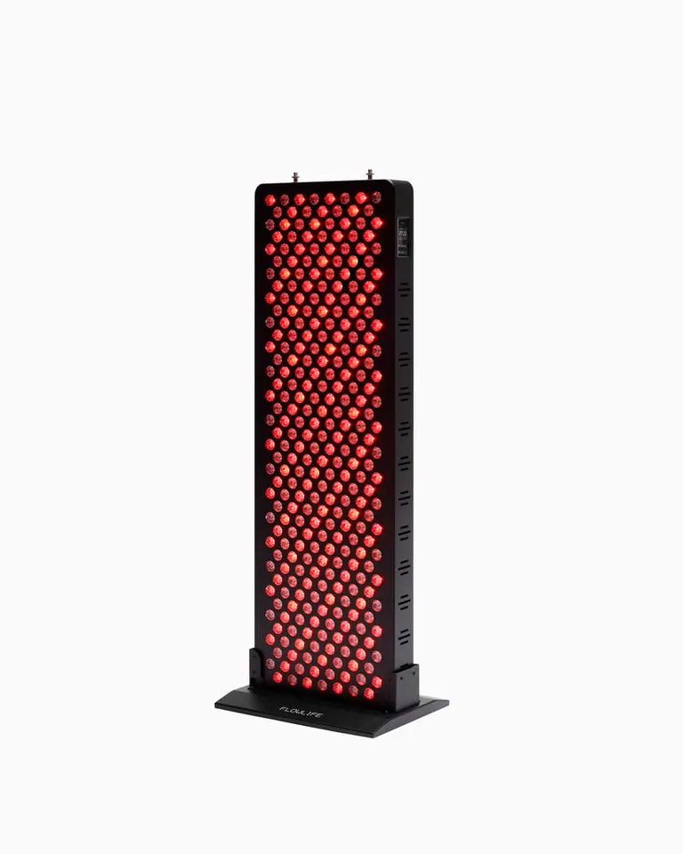 Flowlight Panel 1500 Seven Waves with illuminated red LEDs on a black freestanding base for targeted light therapy.