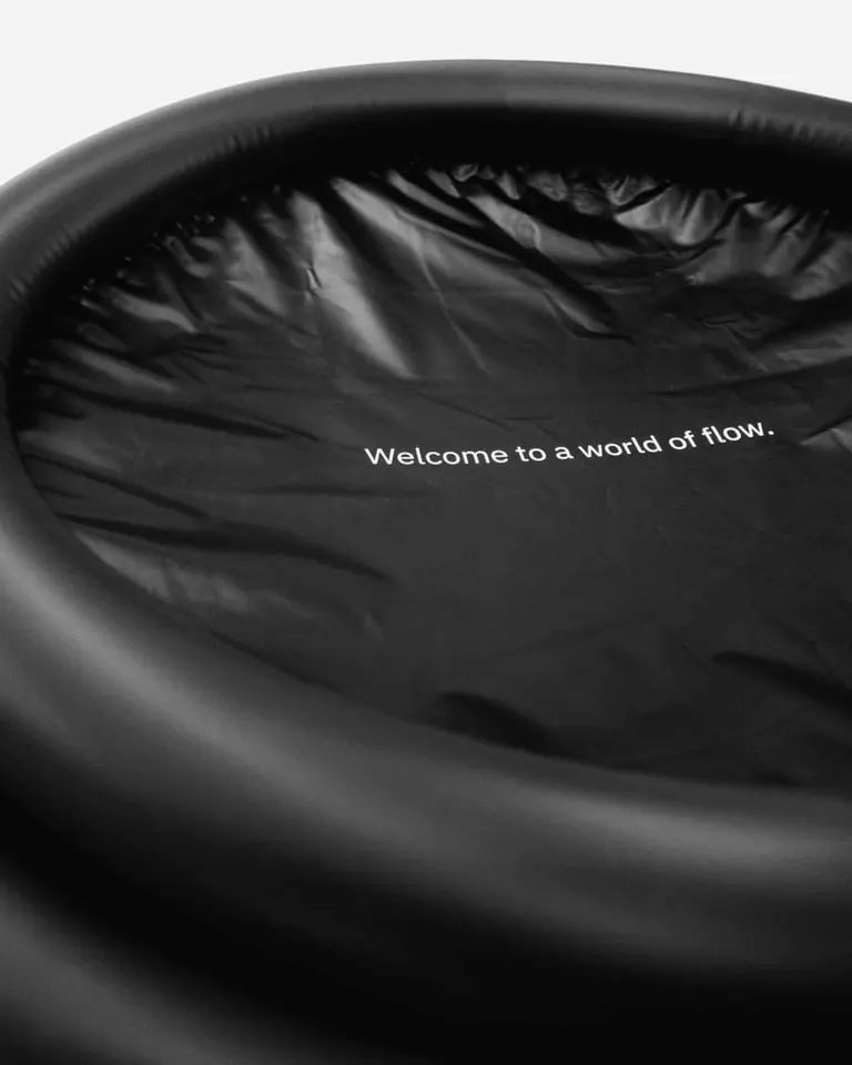 A close-up of the Flowplunge Go portable ice bath, showing the black inflatable rim and interior brand messaging.