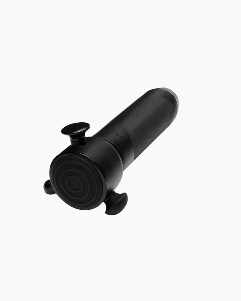 Black Flowsonic Pro+ vibration therapy tool with a textured grip and flat attachment head, shown from an angled view.
