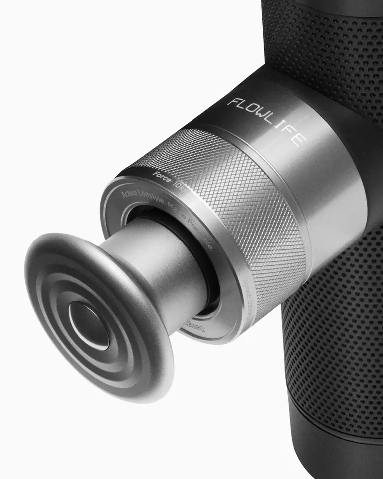 Flowgun ONE percussive therapy massage gun featuring a silver aluminium body, knurled detail, and metal head attachment.