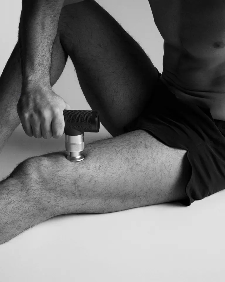 Aluminium Flowgun ONE used for percussive therapy on a thigh.